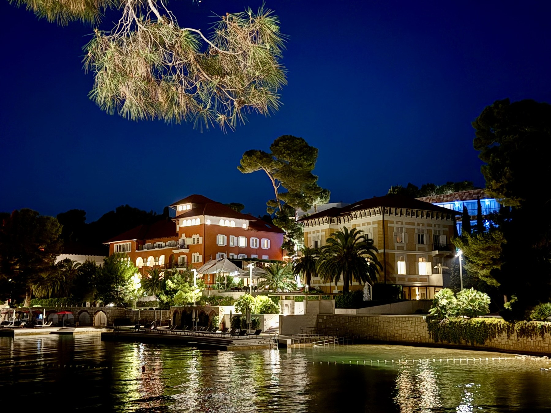 Alhambra hotel illuminated beside the water after dark