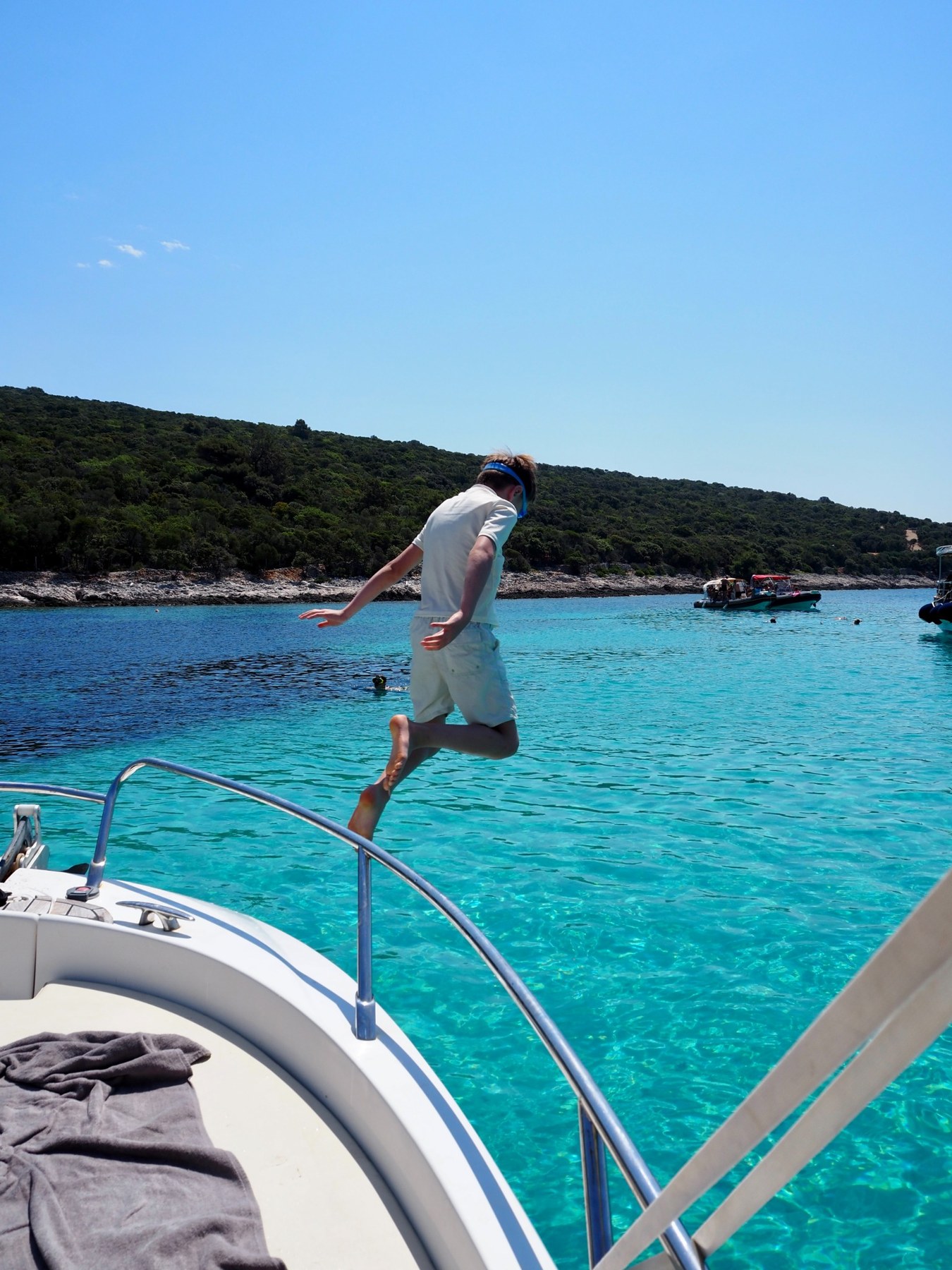 A jump from the boat into turquoise water, viewed from behind